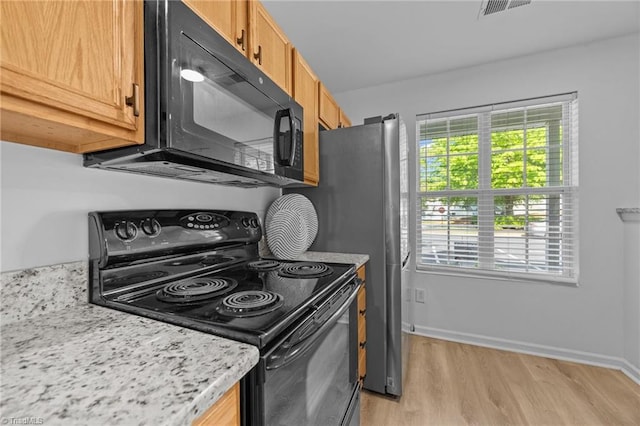 kitchen featuring black appliances, light wood-style floors, and baseboards