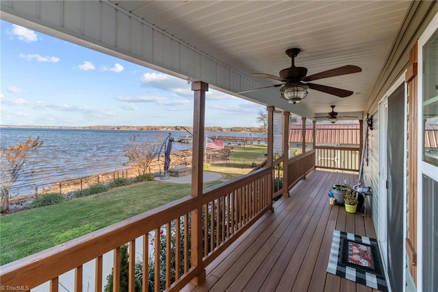 deck with a lawn, ceiling fan, and a water view