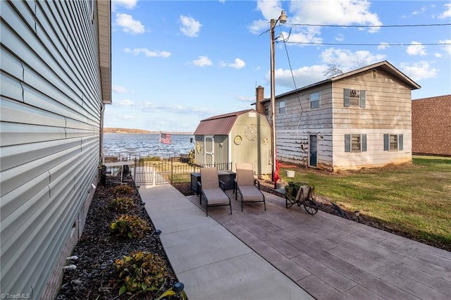 view of patio featuring a water view and a shed