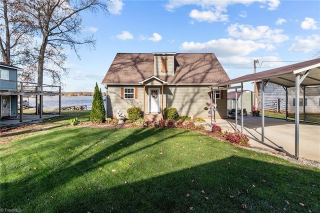 view of front of home featuring a front lawn, a water view, and a carport