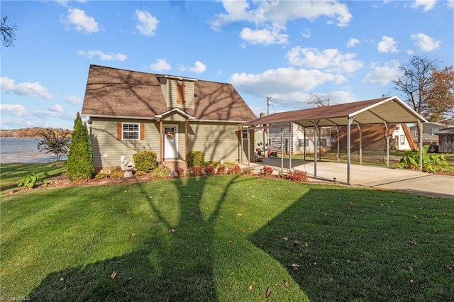 view of front of house with a carport, a water view, and a front lawn