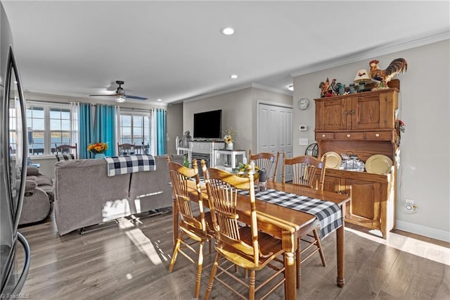 dining room featuring dark hardwood / wood-style flooring, ceiling fan, and ornamental molding