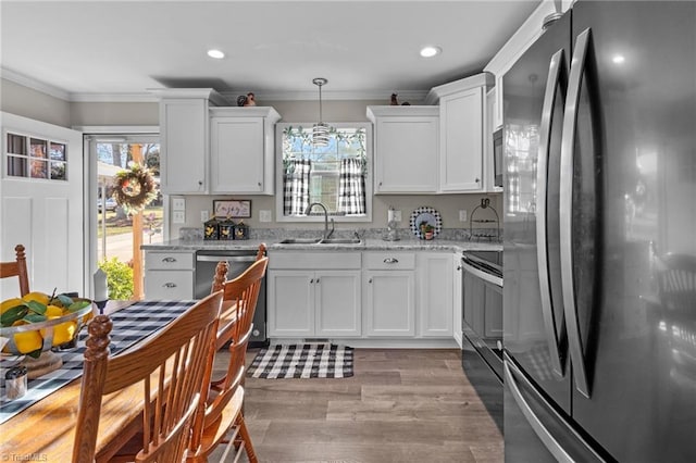 kitchen with sink, crown molding, decorative light fixtures, white cabinetry, and stainless steel appliances