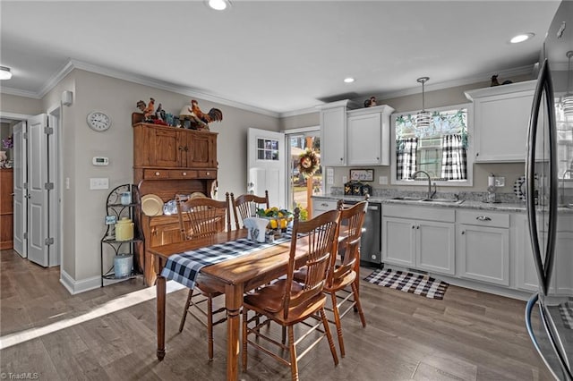 dining area with sink, light hardwood / wood-style floors, and ornamental molding