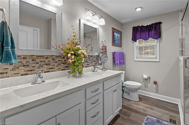 bathroom featuring vanity, decorative backsplash, toilet, an enclosed shower, and wood-type flooring