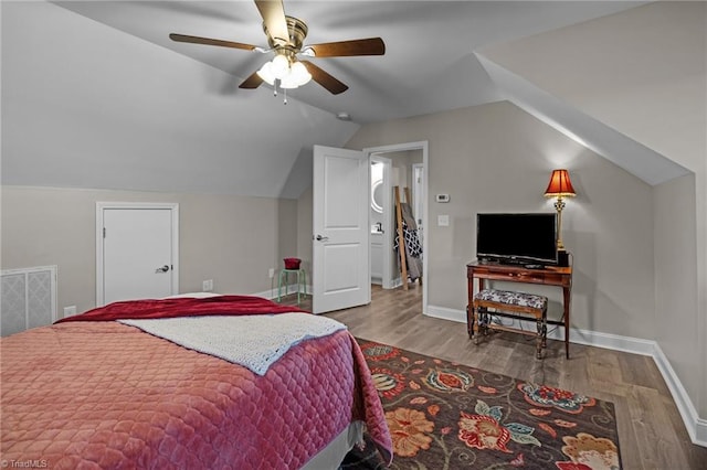 bedroom with ceiling fan, wood-type flooring, and vaulted ceiling