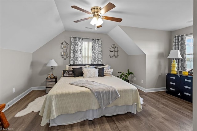 bedroom with ceiling fan, dark hardwood / wood-style floors, and vaulted ceiling