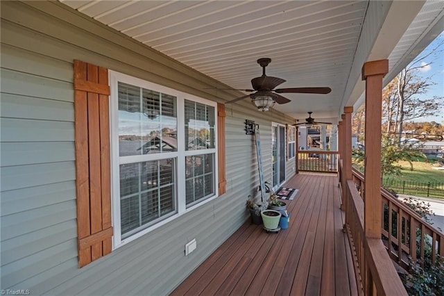 wooden terrace featuring covered porch and ceiling fan