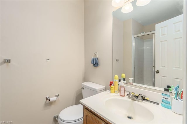 bathroom with vanity, toilet, and a shower with shower door