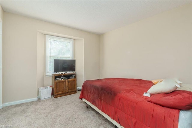 carpeted bedroom featuring baseboards