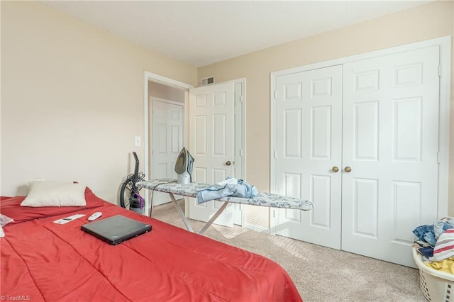 carpeted bedroom featuring a closet and visible vents