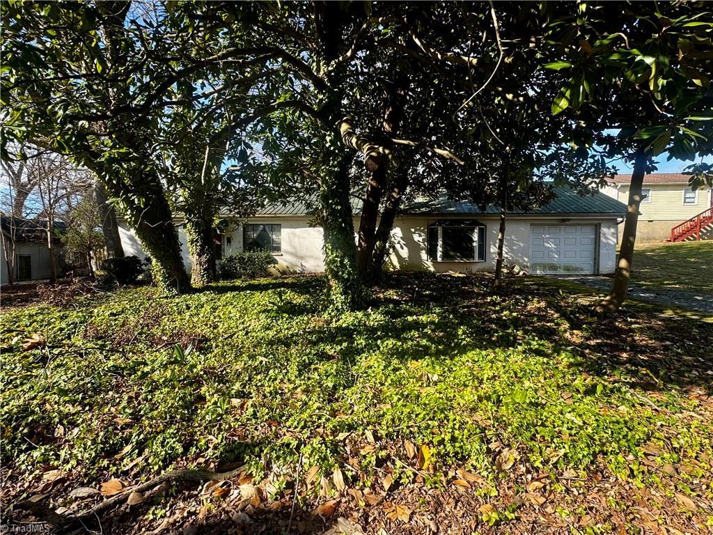 view of front of property featuring an attached garage and a front lawn