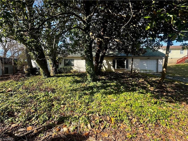 view of front of property featuring an attached garage and a front lawn