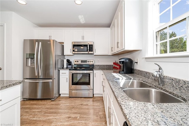 1026 Baileys Chapel Rd, Advance, NC 27006 - kitchen featuring appliances with stainless steel finishes, white cabinetry, recessed lighting, light wood-type flooring, and light stone counters
