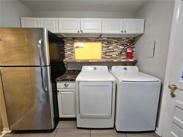 laundry area featuring washing machine and dryer and light tile patterned flooring