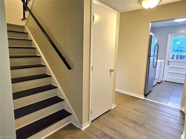 stairs featuring hardwood / wood-style flooring and a textured ceiling