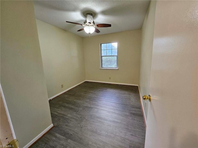 spare room featuring ceiling fan and dark wood-type flooring