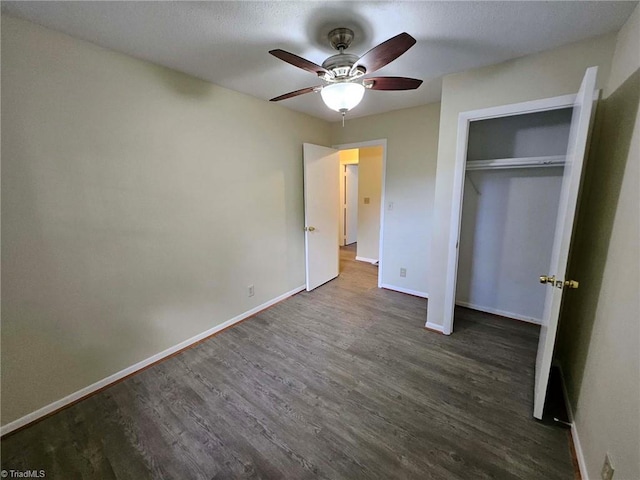 unfurnished bedroom with dark hardwood / wood-style floors, ceiling fan, and a closet