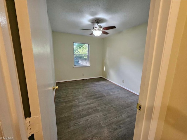 spare room with ceiling fan, dark wood-type flooring, and a textured ceiling