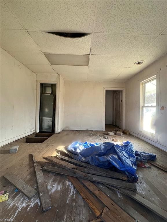 interior space featuring a drop ceiling and hardwood / wood-style flooring