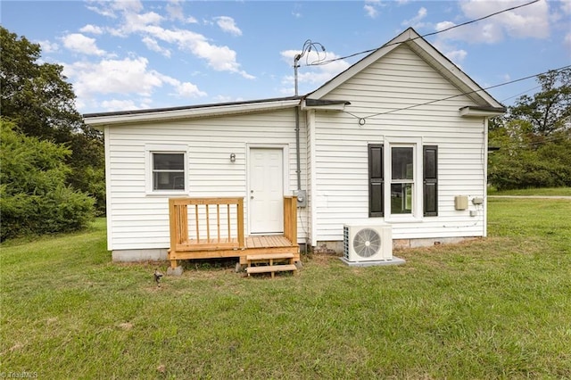 rear view of house featuring a yard and ac unit