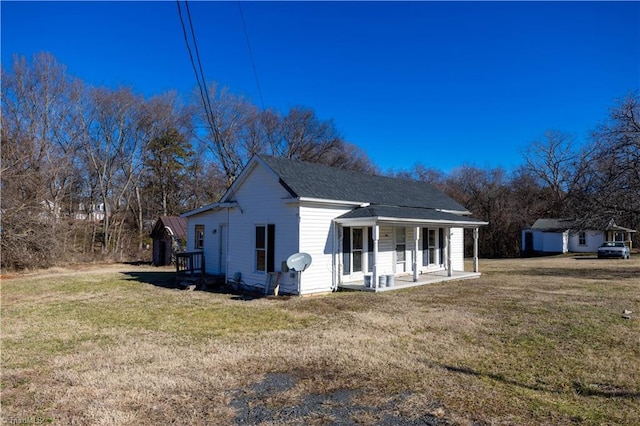 view of property exterior with a shingled roof, a porch, and a yard