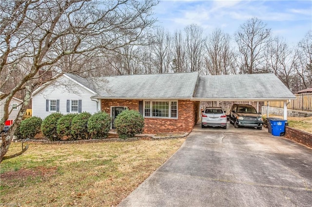 single story home with a carport, a front yard, brick siding, and driveway