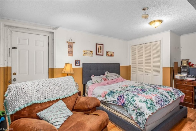 bedroom featuring a textured ceiling, a closet, and light wood-style flooring