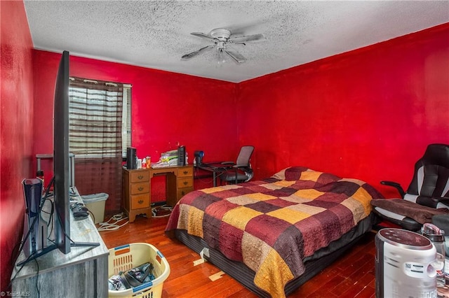 bedroom with dark wood-style floors, a textured ceiling, and a ceiling fan