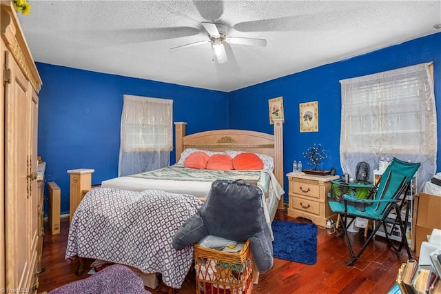 bedroom with dark wood-style floors, ceiling fan, and a textured ceiling