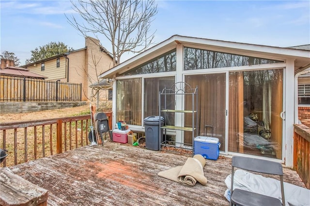 wooden terrace with a sunroom and fence