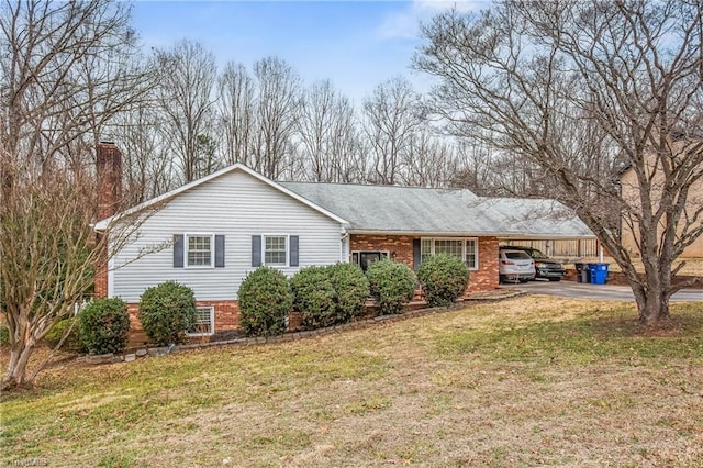 ranch-style home with an attached carport, brick siding, driveway, and a front lawn