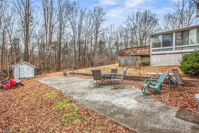 view of yard featuring a storage shed, a sunroom, a patio area, a deck, and an outdoor structure