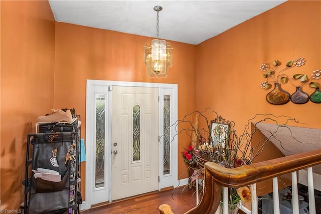 foyer entrance featuring wood finished floors and an inviting chandelier