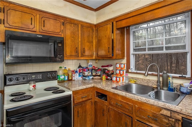 kitchen with tasteful backsplash, brown cabinets, crown molding, black appliances, and a sink