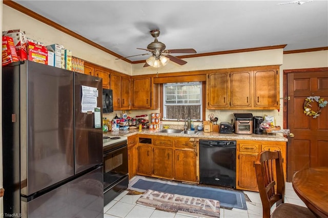 kitchen featuring ornamental molding, brown cabinets, light countertops, black appliances, and a sink