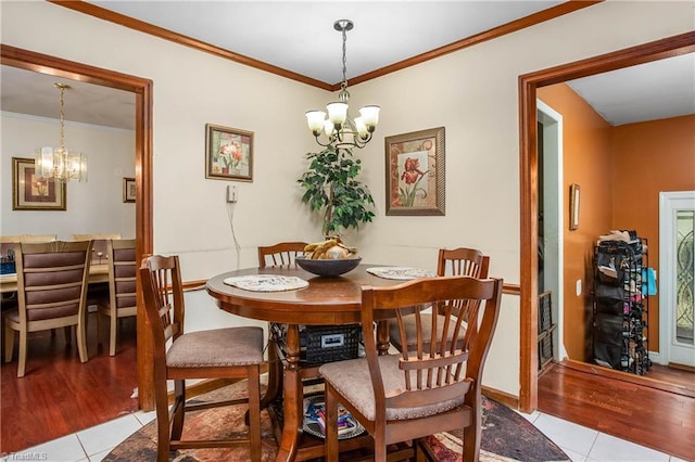 dining room with an inviting chandelier, baseboards, light tile patterned floors, and ornamental molding