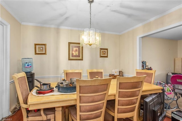 dining area with a chandelier, wood finished floors, and crown molding