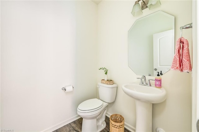 bathroom with wood-type flooring, sink, and toilet