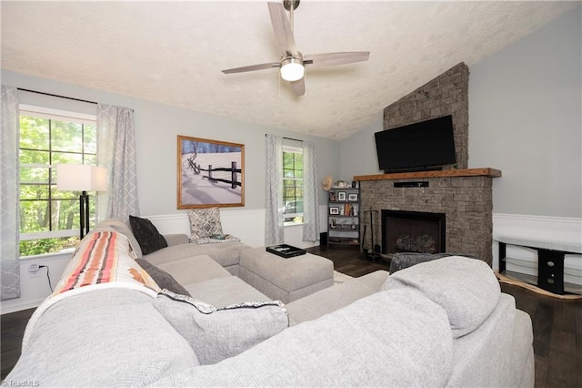 living room featuring a textured ceiling, ceiling fan, wood finished floors, and lofted ceiling