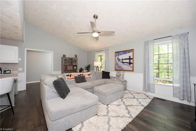 living room featuring a textured ceiling, visible vents, dark wood-style floors, and ceiling fan