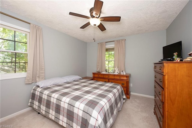 bedroom featuring a textured ceiling, baseboards, and light colored carpet