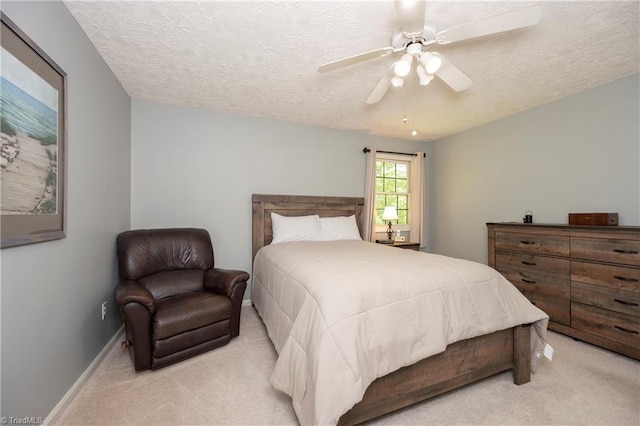 bedroom with baseboards, a textured ceiling, light carpet, and ceiling fan
