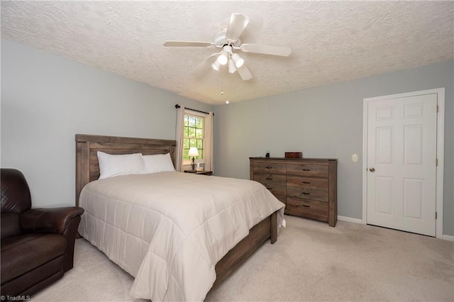 bedroom featuring baseboards, a ceiling fan, a textured ceiling, and light colored carpet