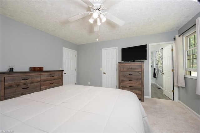 bedroom featuring baseboards, a ceiling fan, carpet flooring, and a textured ceiling