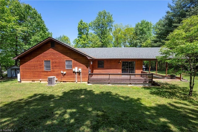 back of house with a storage unit, an outbuilding, a wooden deck, and a yard