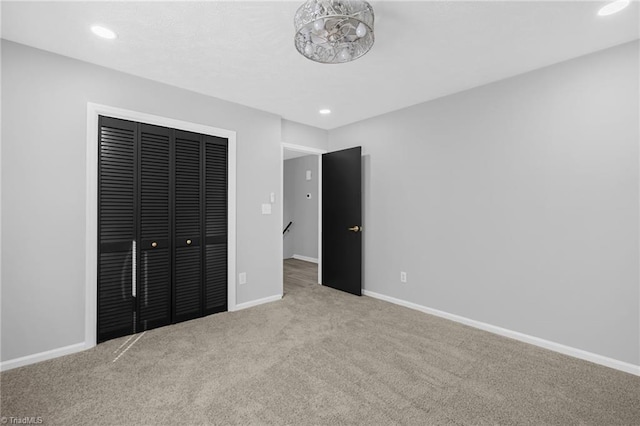 unfurnished bedroom featuring a closet and light carpet