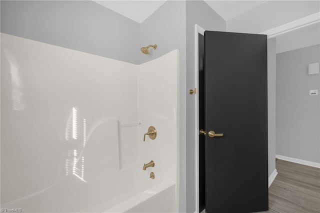 bathroom featuring hardwood / wood-style flooring and  shower combination