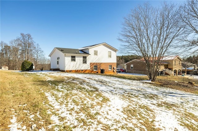 view of snow covered back of property