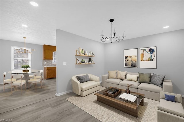 living room with an inviting chandelier and light hardwood / wood-style floors